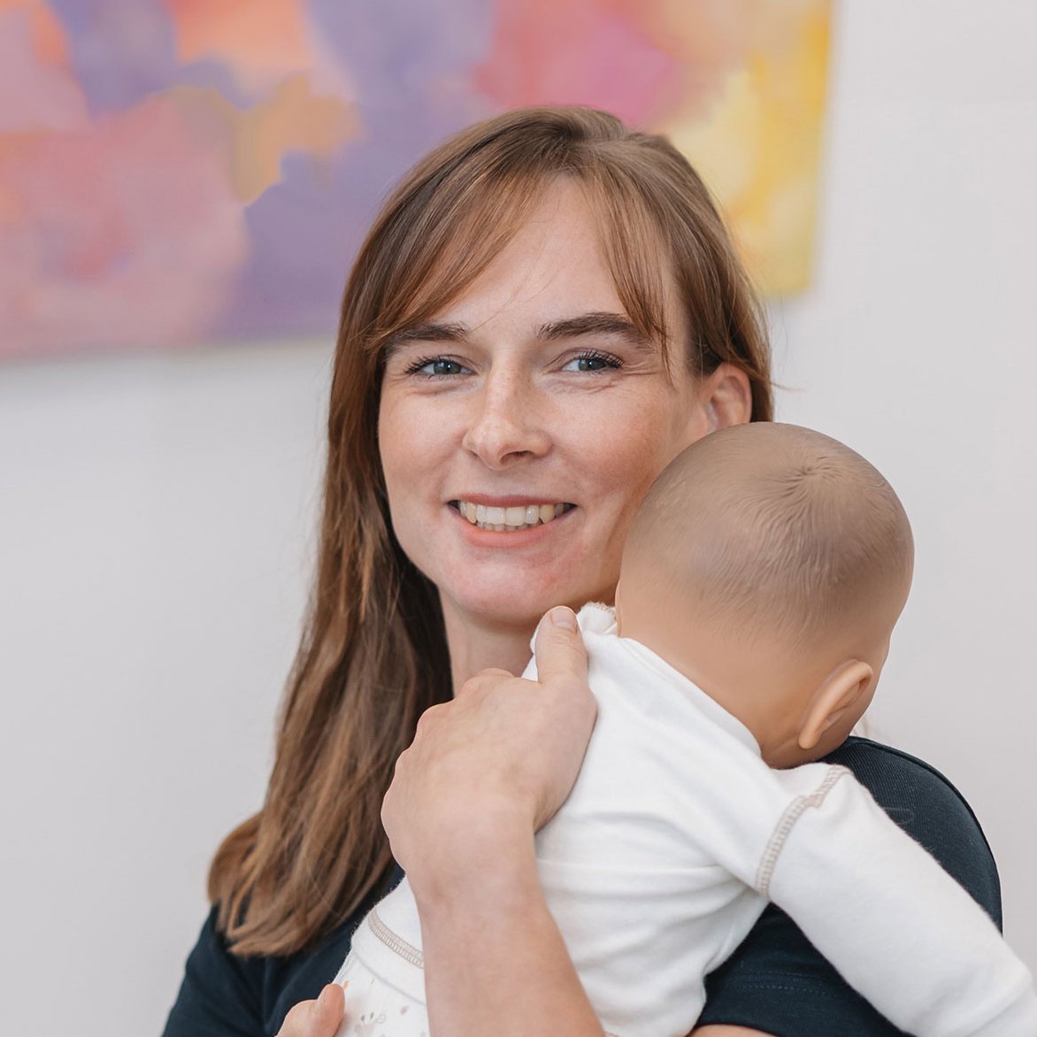 Nicole Amoussou mit Kind auf dem Arm - Kinderosteophatie in der Praxis für Osteopathie und Physiotherapie Amoussou